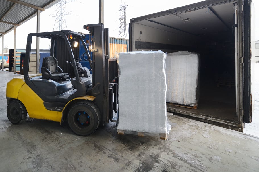 Forklift putting skid onto truck